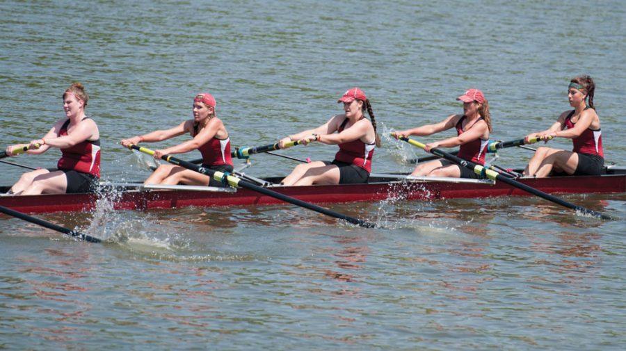 A group of people rowing a boat in the water

Description automatically generated